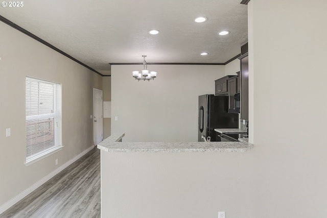 14426 NW Larson Rd Unit 2, Portland, OR 97231 - kitchen with freestanding refrigerator, crown molding, light countertops, a chandelier, and recessed lighting