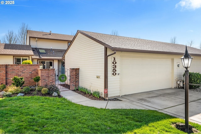 view of front of house featuring a front yard, a gate, fence, a garage, and driveway