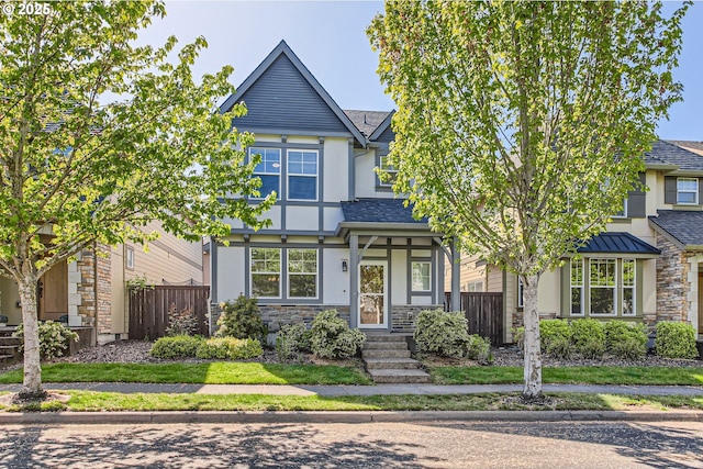 view of front of home featuring a shingled roof, stucco siding, stone siding, and fence