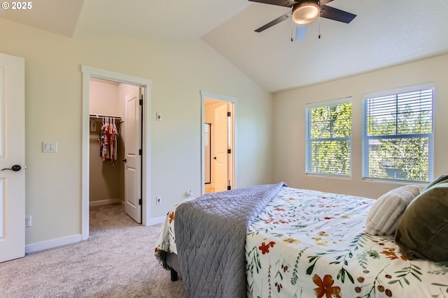 bedroom featuring light colored carpet, baseboards, vaulted ceiling, a spacious closet, and a closet