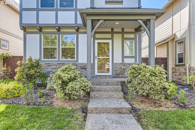 property entrance featuring stone siding and stucco siding