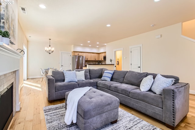 living room with recessed lighting, light wood finished floors, and a chandelier