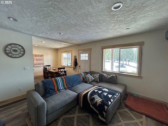 living room with recessed lighting, a textured ceiling, baseboards, and wood finished floors