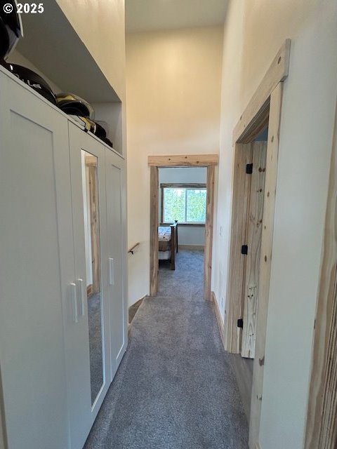 corridor featuring carpet floors and a towering ceiling