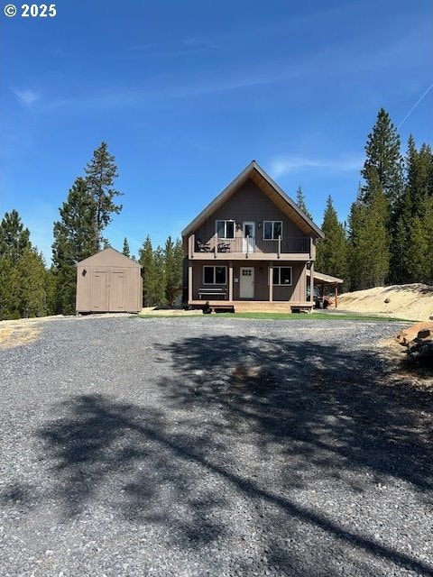 chalet / cabin with a storage shed, an outdoor structure, and a wooden deck