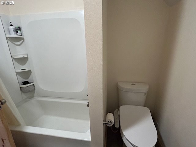 full bathroom with a bathing tub, walk in shower, and toilet