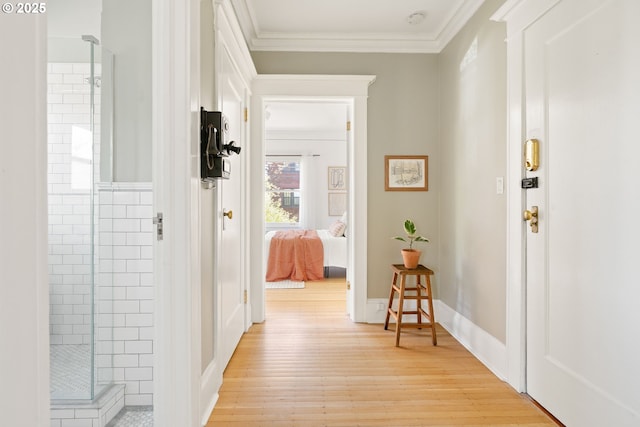 hall with light wood-type flooring and crown molding