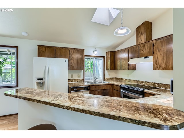 kitchen with stainless steel electric range, a sink, white fridge with ice dispenser, under cabinet range hood, and lofted ceiling with skylight