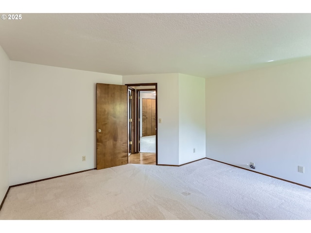 carpeted empty room featuring baseboards