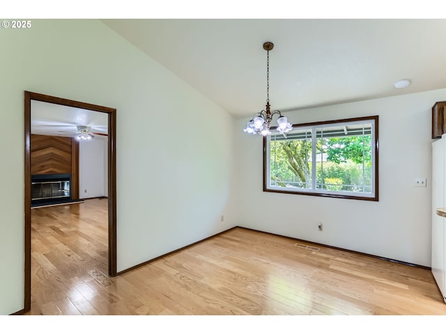 spare room with a chandelier, visible vents, and light wood-style floors
