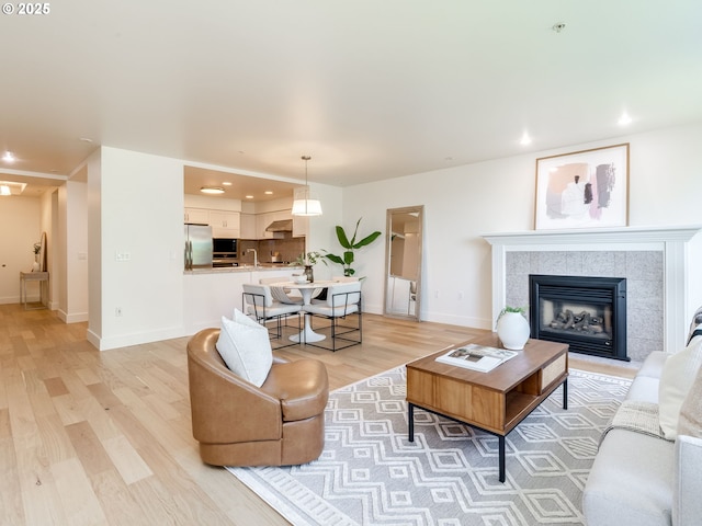 790 NW Westover Sq Unit 8, Portland, OR 97210 - living room featuring light wood-style floors, recessed lighting, baseboards, and a tile fireplace