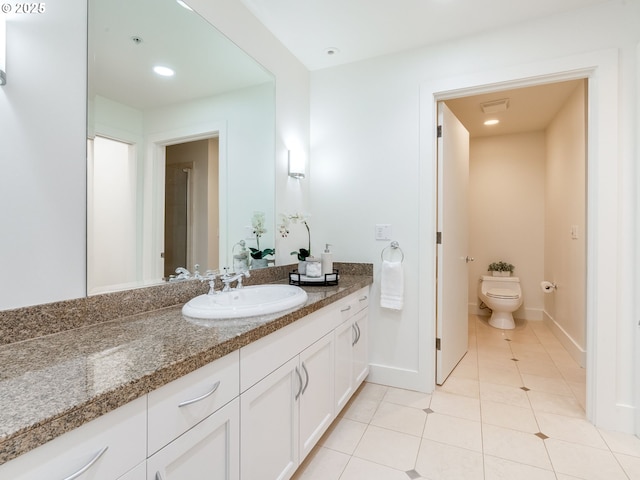 790 NW Westover Sq Unit 8, Portland, OR 97210 - bathroom with vanity, tile patterned flooring, toilet, baseboards, and recessed lighting
