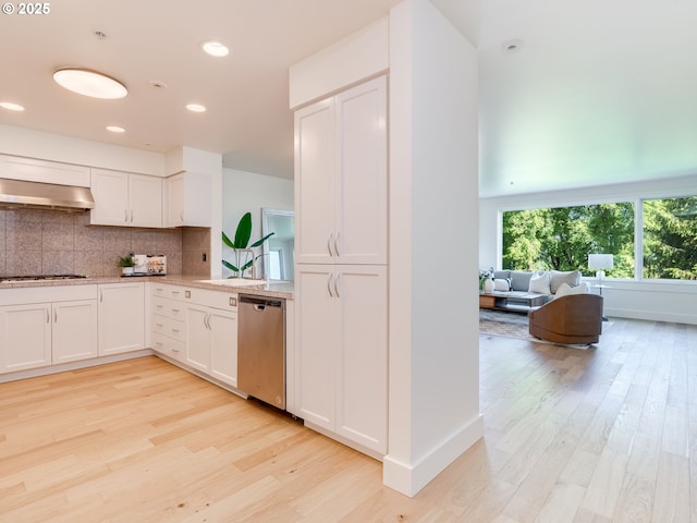 790 NW Westover Sq Unit 8, Portland, OR 97210 - kitchen featuring stainless steel dishwasher, light wood-style floors, wall chimney range hood, white cabinetry, and backsplash