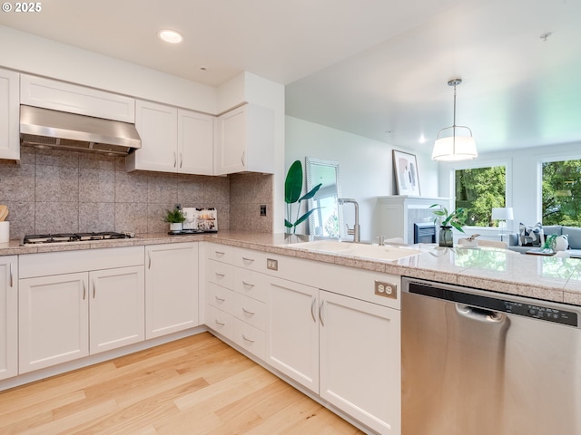 790 NW Westover Sq Unit 8, Portland, OR 97210 - kitchen featuring stainless steel appliances, wall chimney exhaust hood, a sink, tile counters, and white cabinets