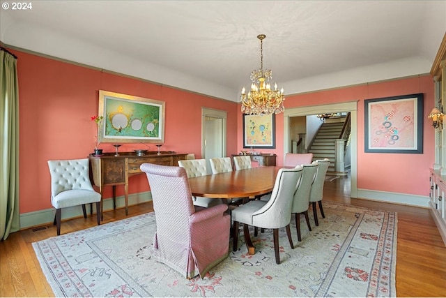 dining space featuring light hardwood / wood-style floors and a notable chandelier