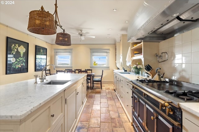 kitchen with a kitchen island with sink, ventilation hood, ceiling fan, sink, and backsplash