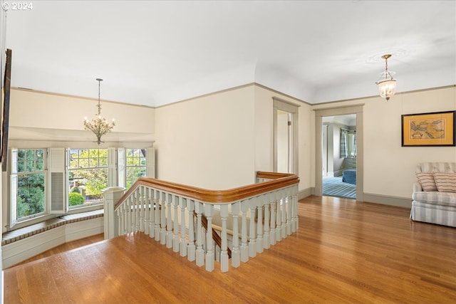 corridor featuring a notable chandelier and hardwood / wood-style flooring