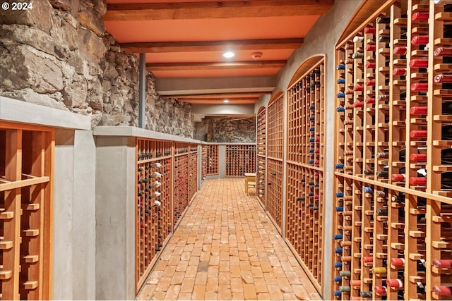 wine room featuring beam ceiling