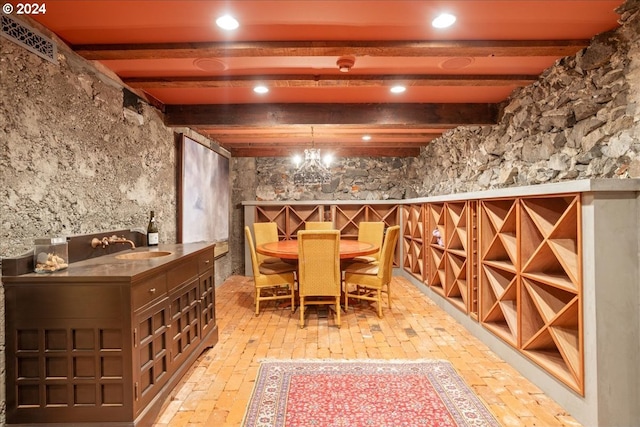 wine cellar featuring an inviting chandelier, beam ceiling, and sink