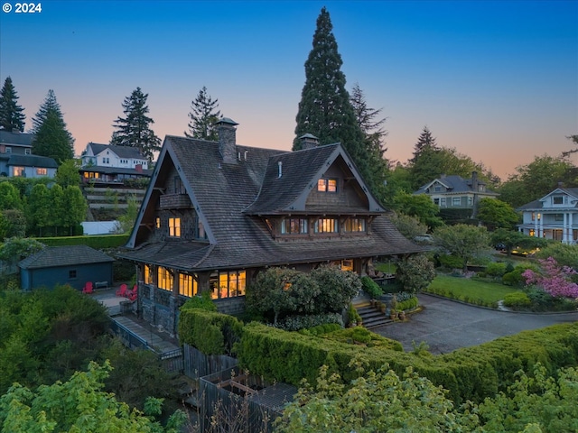 back house at dusk with an outdoor structure