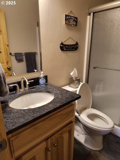 full bath with vanity, toilet, and a stall shower