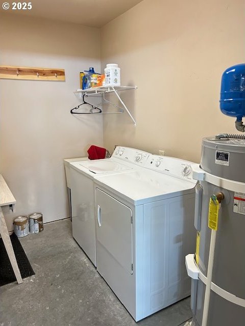 clothes washing area with independent washer and dryer, water heater, and laundry area