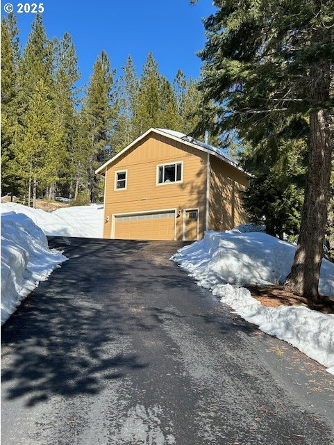 snow covered property with a garage