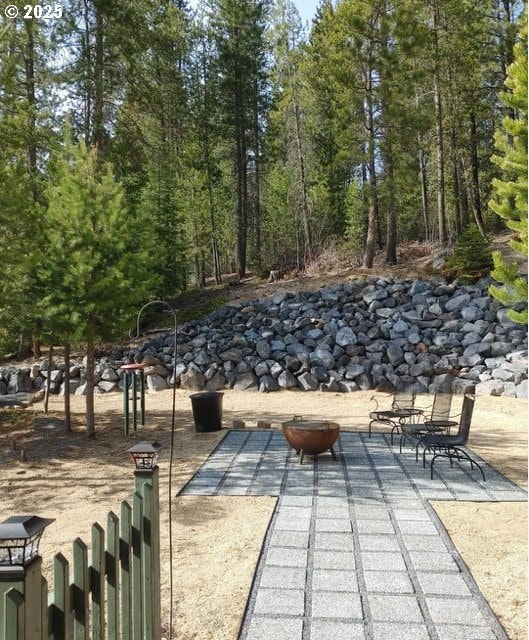 surrounding community with a fire pit and a patio