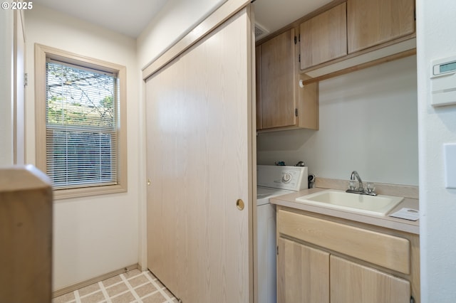 clothes washing area with cabinets, washer / dryer, and sink