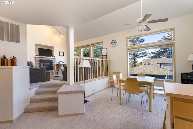 dining space featuring vaulted ceiling, light colored carpet, and ceiling fan