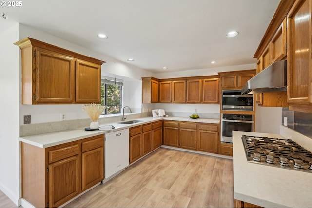 950 NW 161st Ter, Beaverton, OR 97006 - kitchen with stainless steel appliances, a sink, light wood-type flooring, light countertops, and under cabinet range hood