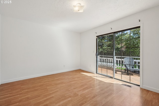 950 NW 161st Ter, Beaverton, OR 97006 - empty room with baseboards, light wood-style flooring, visible vents, and a textured ceiling
