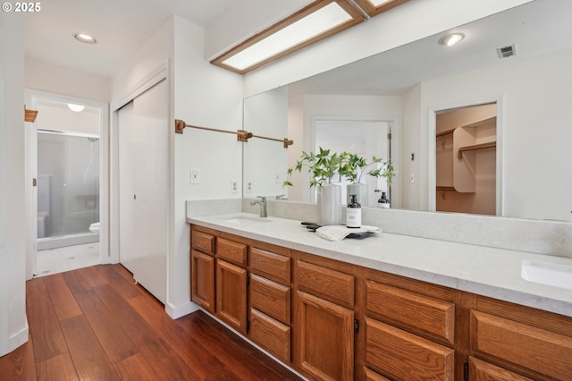 950 NW 161st Ter, Beaverton, OR 97006 - full bathroom featuring a shower stall, wood finished floors, a spacious closet, vanity, and visible vents