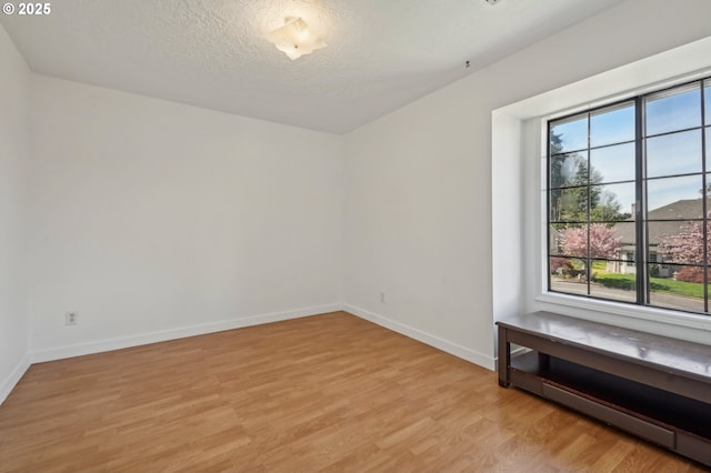 950 NW 161st Ter, Beaverton, OR 97006 - unfurnished room featuring a textured ceiling, light wood finished floors, and baseboards