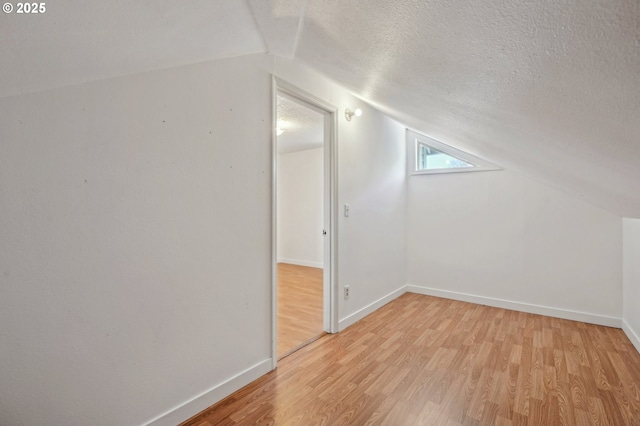 950 NW 161st Ter, Beaverton, OR 97006 - additional living space with light wood-type flooring, a textured ceiling, lofted ceiling, and baseboards