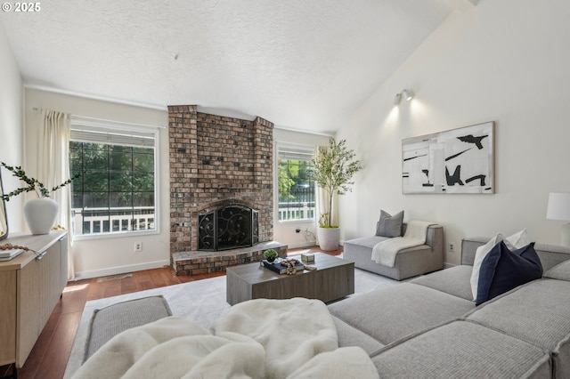 950 NW 161st Ter, Beaverton, OR 97006 - living room featuring vaulted ceiling, a brick fireplace, wood finished floors, and a textured ceiling