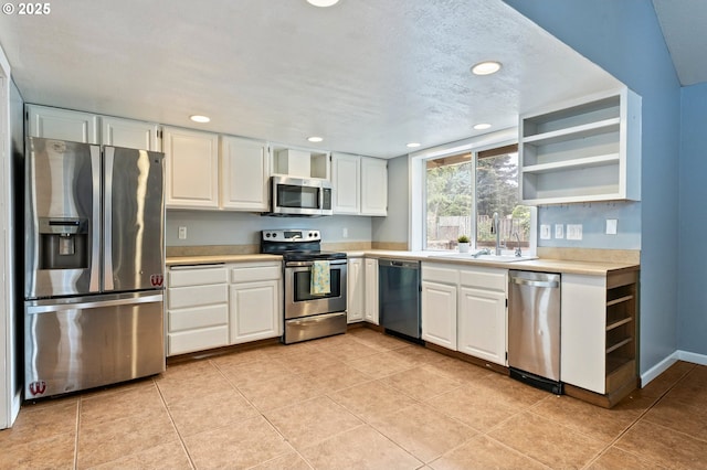 4935 NW Kahneeta Ct, Portland, OR 97229 - kitchen with appliances with stainless steel finishes, open shelves, light countertops, white cabinetry, and recessed lighting