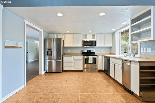 4935 NW Kahneeta Ct, Portland, OR 97229 - kitchen featuring stainless steel appliances, open shelves, light countertops, recessed lighting, and white cabinets