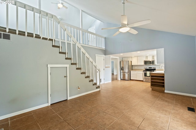 4935 NW Kahneeta Ct, Portland, OR 97229 - unfurnished living room with high vaulted ceiling, ceiling fan, light tile patterned floors, and stairway
