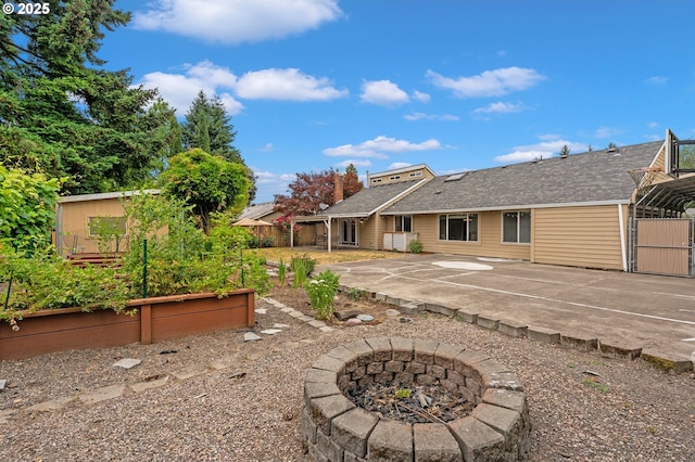 4935 NW Kahneeta Ct, Portland, OR 97229 - rear view of property with a patio, a fire pit, a vegetable garden, uncovered parking, and a shingled roof