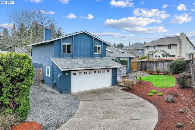 view of front of home with a chimney, an attached garage, concrete driveway, and fence