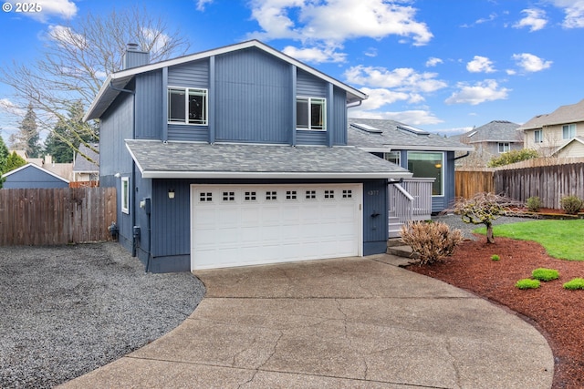 view of front of home with fence, roof with shingles, concrete driveway, a garage, and a chimney