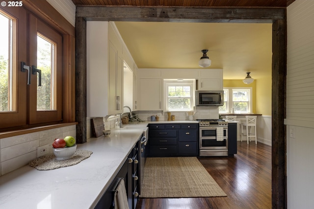 1040 S Park St, Carlton, OR 97111 - kitchen with appliances with stainless steel finishes, white cabinets, dark wood-type flooring, and backsplash