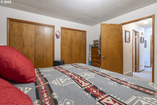 3419 S Ballard Ln, Lincoln City, OR 97367 - carpeted bedroom featuring multiple closets and a textured ceiling