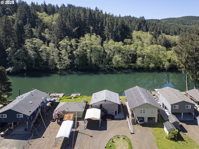 3419 S Ballard Ln, Lincoln City, OR 97367 - aerial view of property and surrounding area featuring a heavily wooded area, a nearby body of water, and nearby suburban area