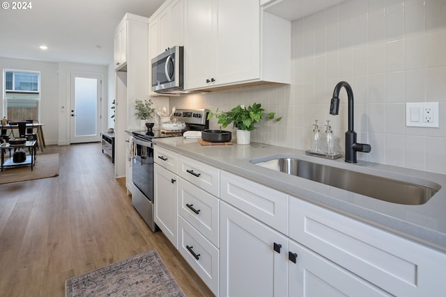 kitchen featuring appliances with stainless steel finishes, sink, decorative backsplash, and white cabinets