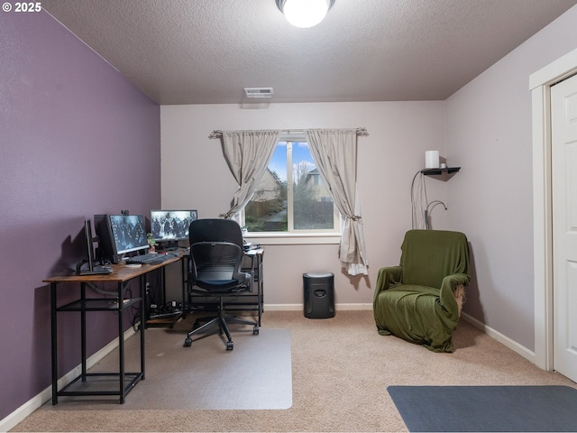 carpeted office space featuring a textured ceiling