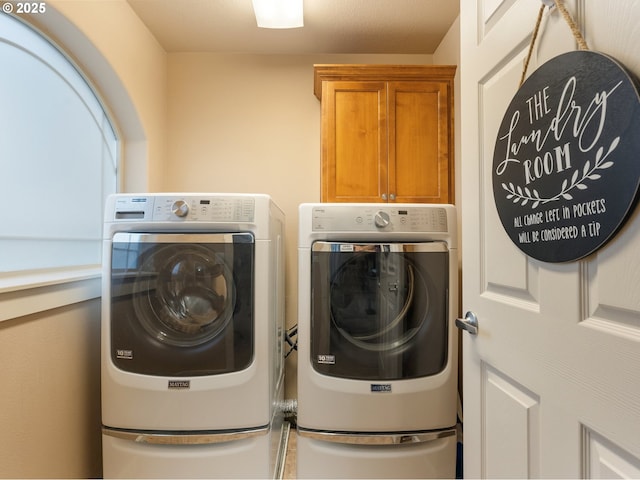 clothes washing area featuring cabinets and washing machine and dryer