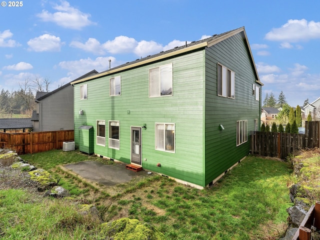 back of house with cooling unit, a yard, and a patio