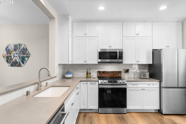 9619 NW Silver Ridge Loop, Portland, OR 97229 - kitchen featuring appliances with stainless steel finishes, a sink, recessed lighting, light countertops, and white cabinets
